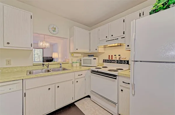 a kitchen with cabinets appliances a sink and a counter top space