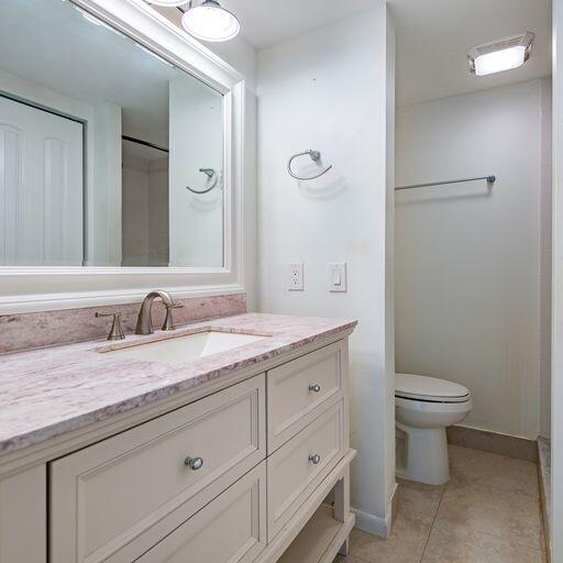 250 Northeast 20th Street, Unit 3210 Boca Raton, FL 33431 - Photo 22 of 26 a bathroom with a granite countertop sink a toilet and a mirror