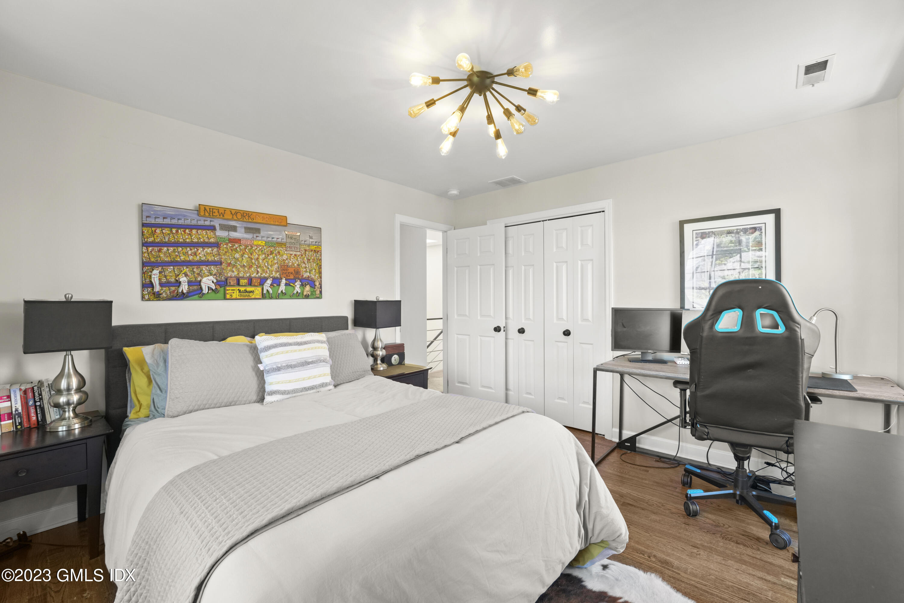 172 Field Point Road, Unit 6 Greenwich, CT 06830 - Photo 22 of 36 a bedroom with a bed and a chandelier