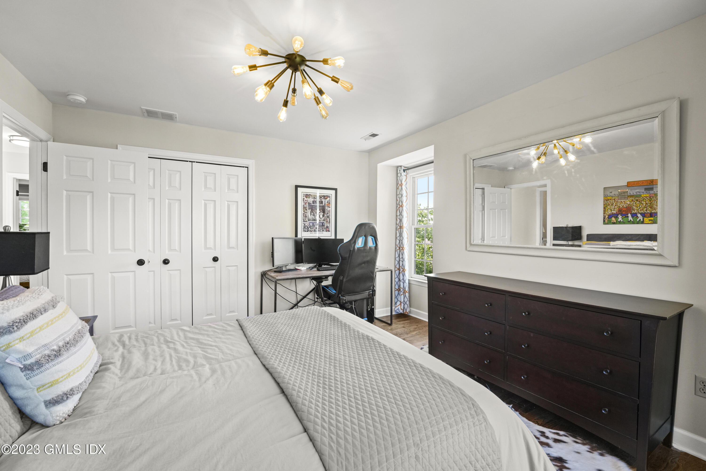 172 Field Point Road, Unit 6 Greenwich, CT 06830 - Photo 24 of 36 a bedroom with a bed and a chandelier
