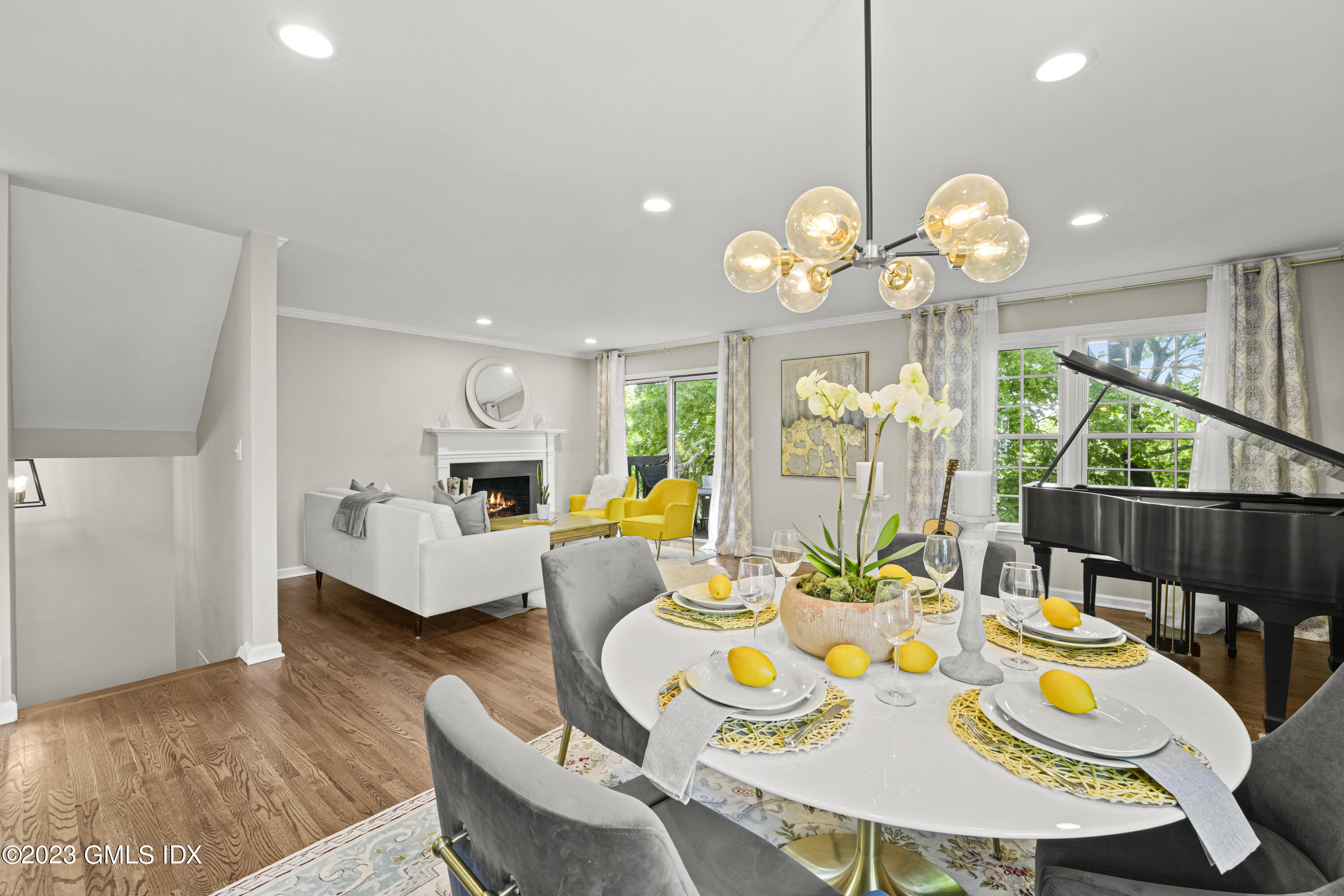 172 Field Point Road, Unit 6 Greenwich, CT 06830 - Photo 3 of 36 a view of a dining room with furniture a chandelier and wooden floor