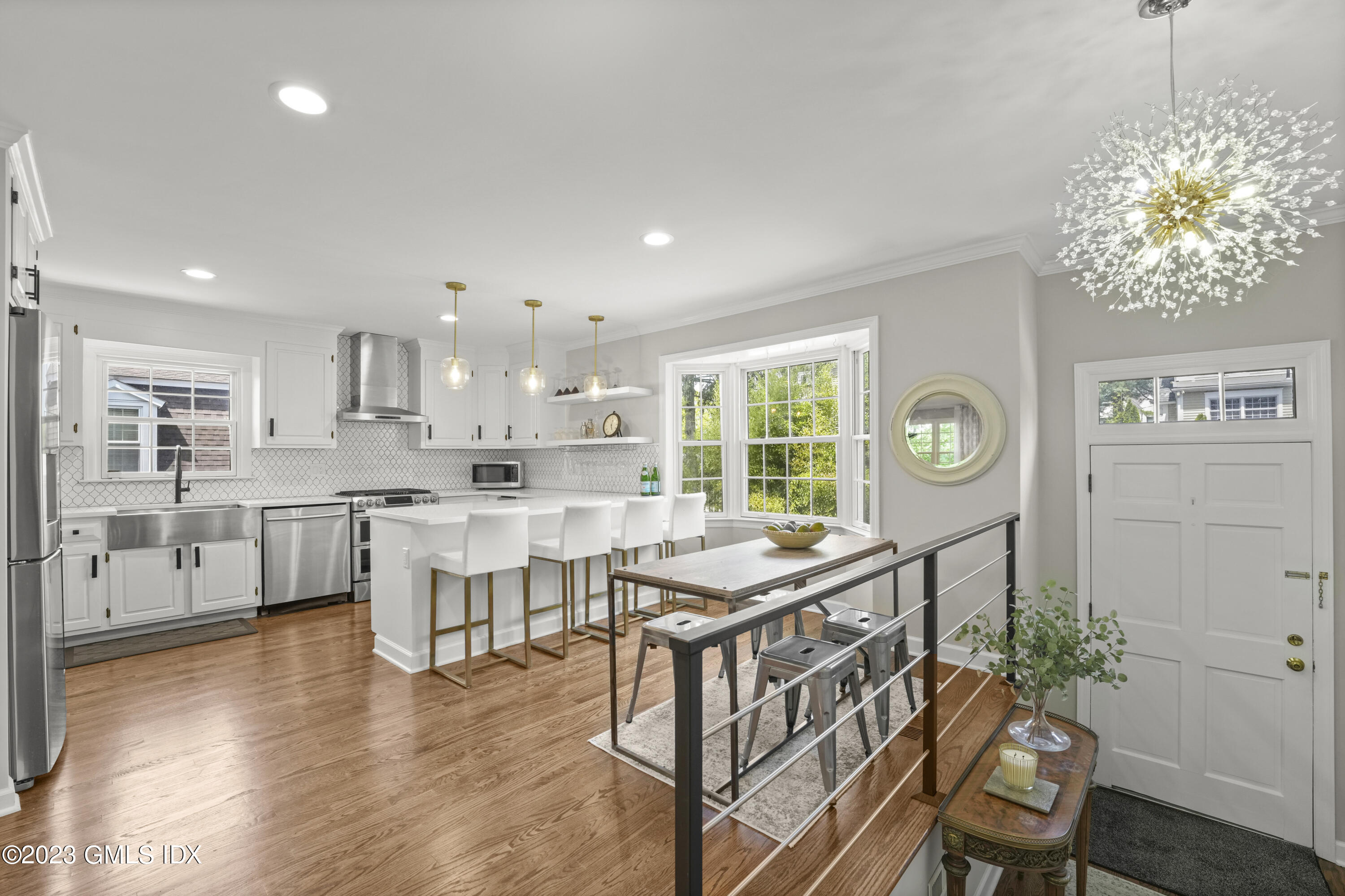 172 Field Point Road, Unit 6 Greenwich, CT 06830 - Photo 7 of 36 a kitchen with stainless steel appliances granite countertop a kitchen island a stove a table and chairs in it