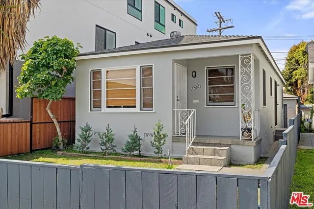 a view of a house with a wooden floor and a yard with furniture