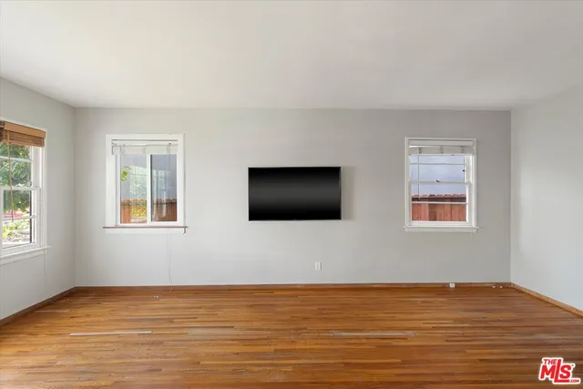 an empty room with a window and a ceiling fan