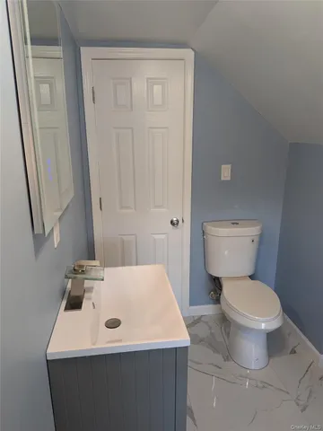 a bathroom with a sink toilet and a mirror
