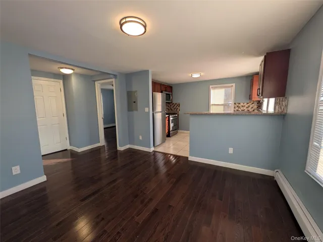 a view of a kitchen with wooden floor and a window