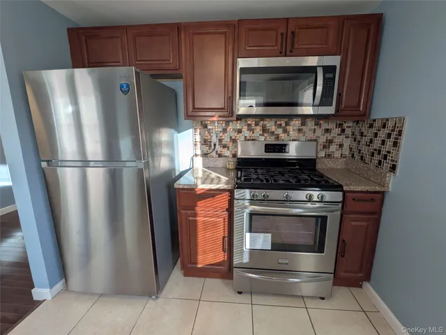 a kitchen with granite countertop a refrigerator and a stove top oven