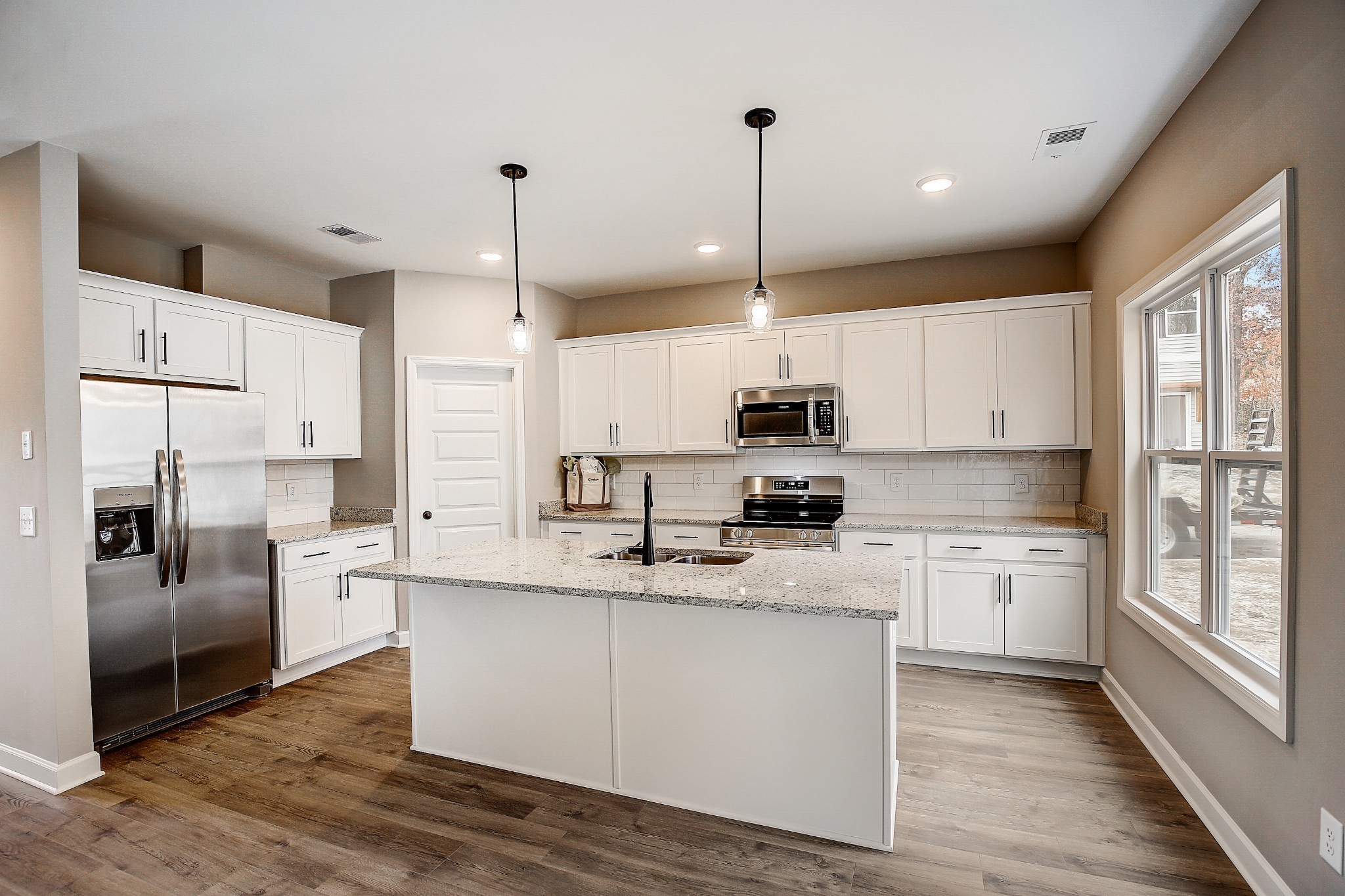 1776 Fenway Loop Antioch, TN 37013 - Photo 9 of 39 a kitchen with stainless steel appliances granite countertop a refrigerator a sink dishwasher a stove and white cabinets with wooden floor