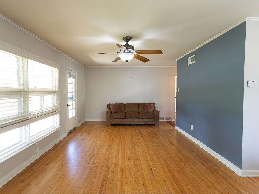 1089 Ivy Road Memphis, TN 38117 - Photo 16 of 32 a big room with wooden floor a chandelier fan and windows