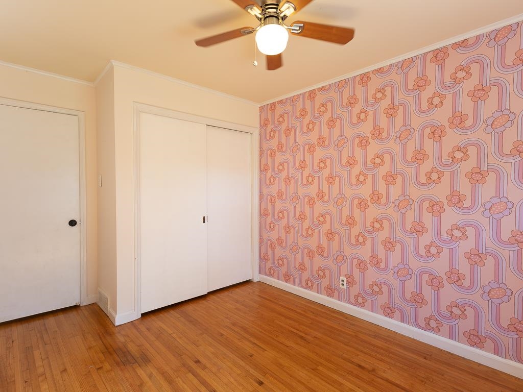 1089 Ivy Road Memphis, TN 38117 - Photo 21 of 32 a view of an empty room with wooden floor and a ceiling fan