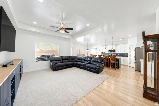5963 Flattop Drive St. George, UT 84790 - Photo 7 of 45 Open-concept living area with tray ceiling, recessed lighting, and a ceiling fan