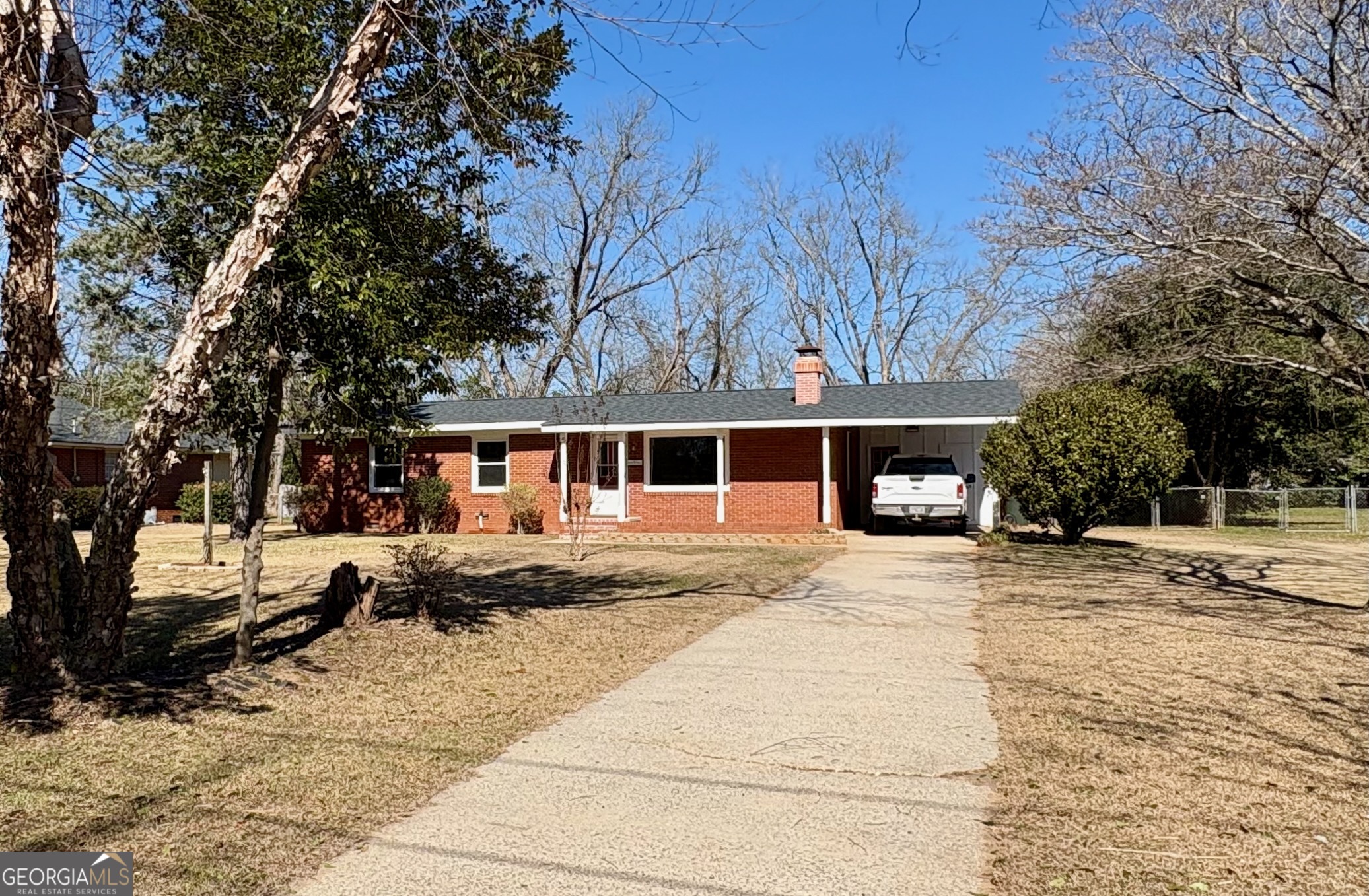 a front view of a house with a yard covered in snow