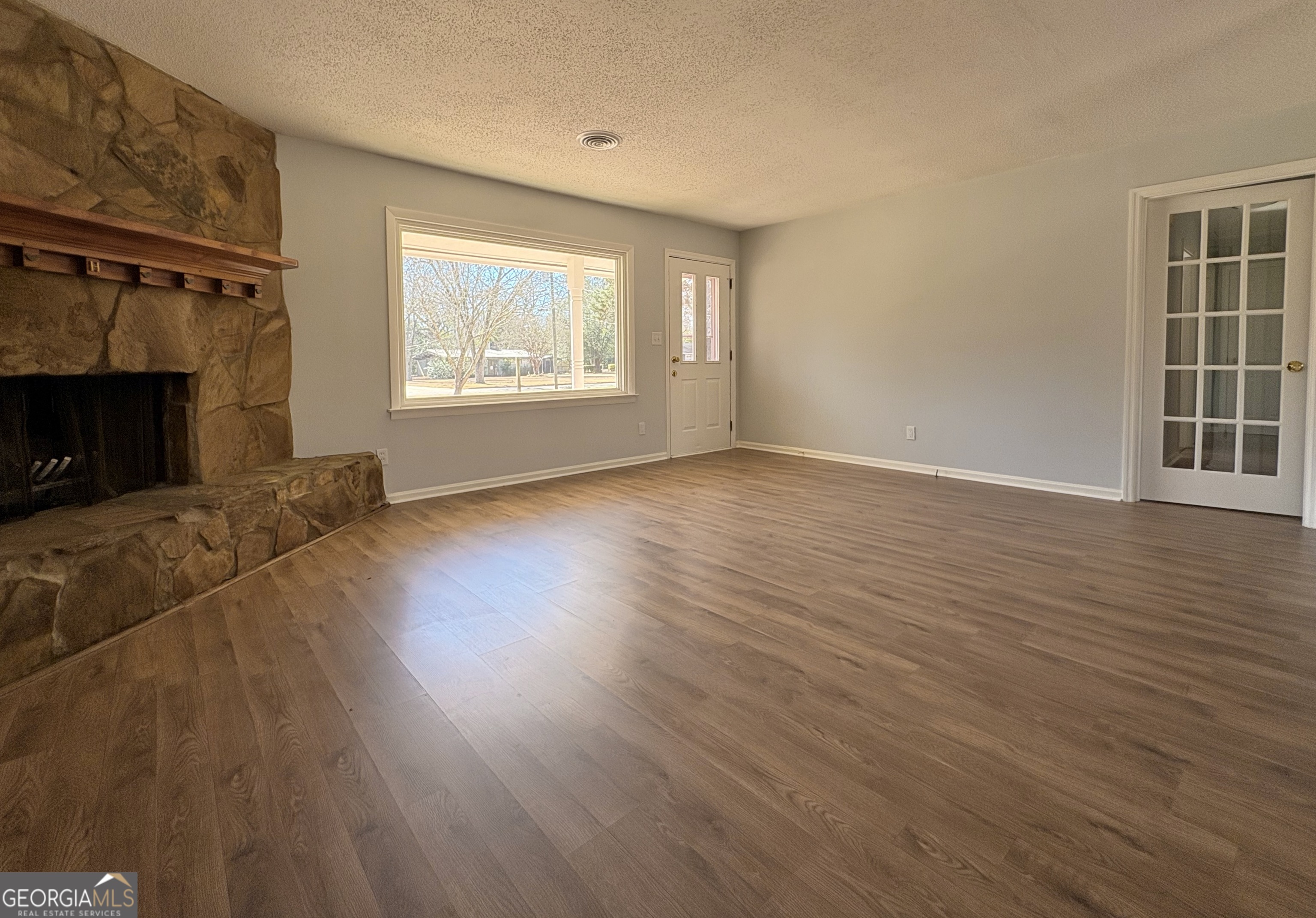 404 Magnolia Street Fort Valley, GA 31030 - Photo 3 of 21 a view of an empty room with wooden floor fireplace and a window