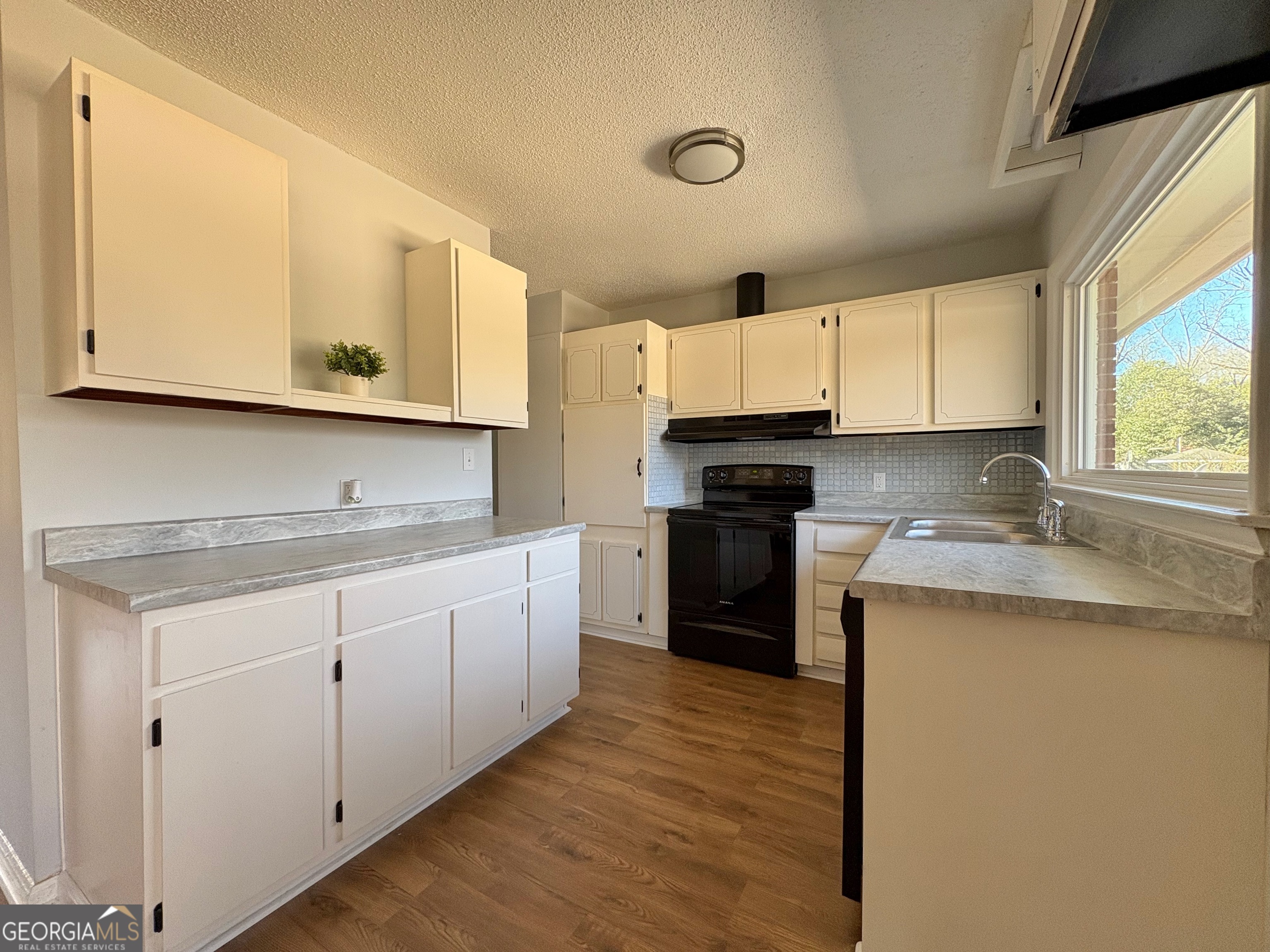 404 Magnolia Street Fort Valley, GA 31030 - Photo 9 of 21 a kitchen with granite countertop cabinets stainless steel appliances a sink and a window