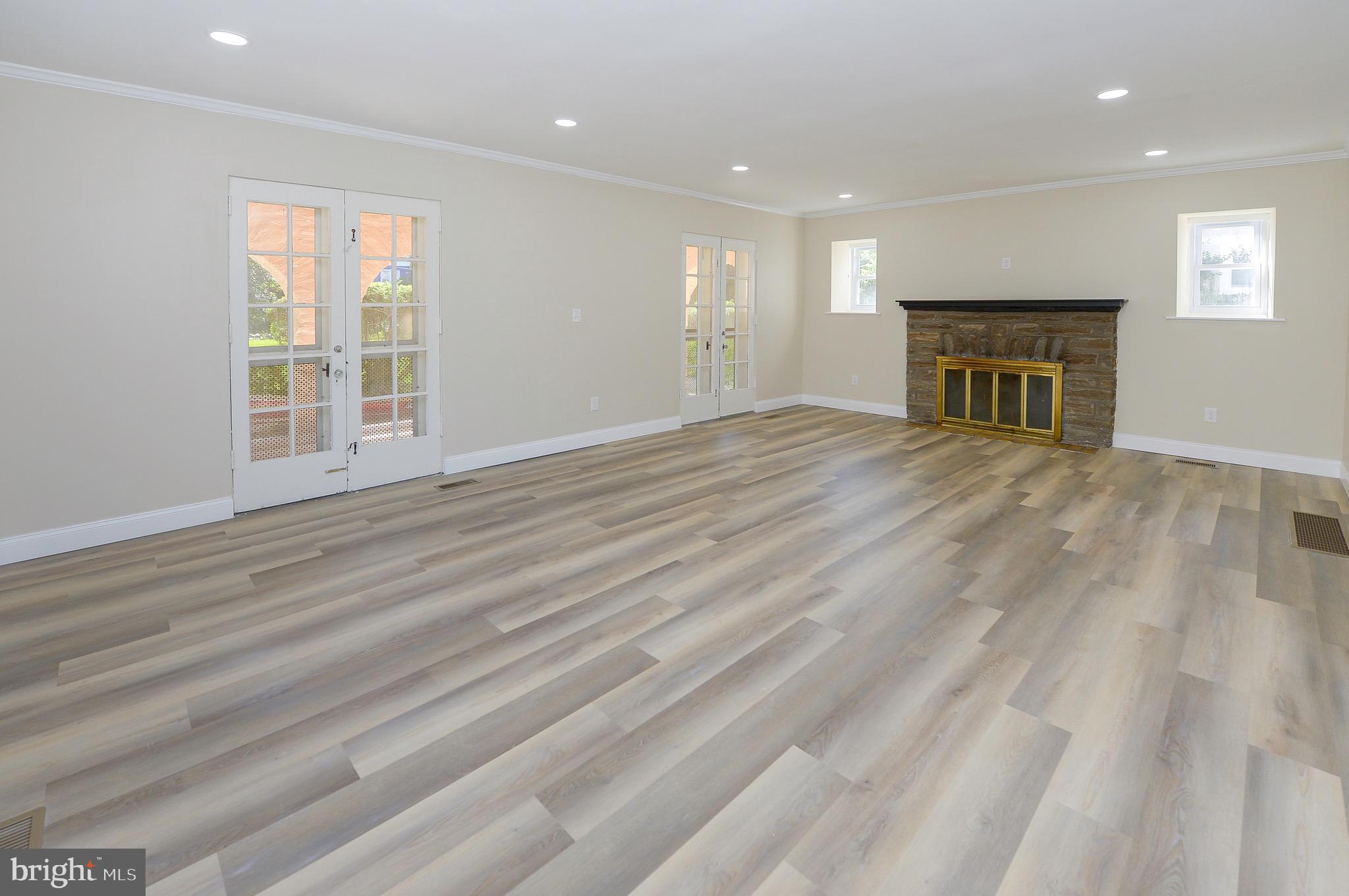 537 Church Road Elkins Park, PA 19027 - Photo 15 of 39 an empty room with wooden floor fireplace and windows