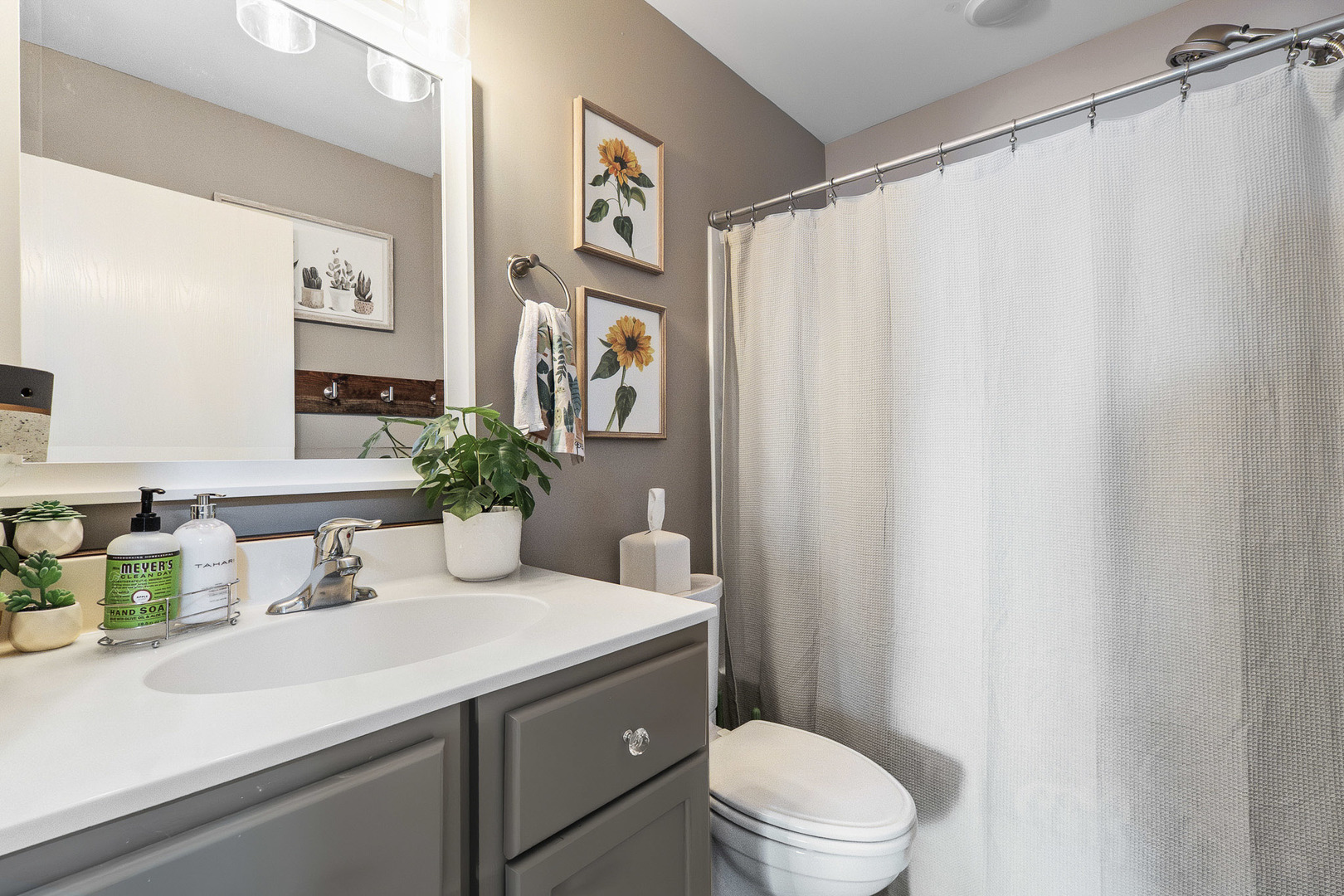 712 Wilson Street Waterman, IL 60556 - Photo 17 of 24 a bathroom with a sink a toilet and shower curtain