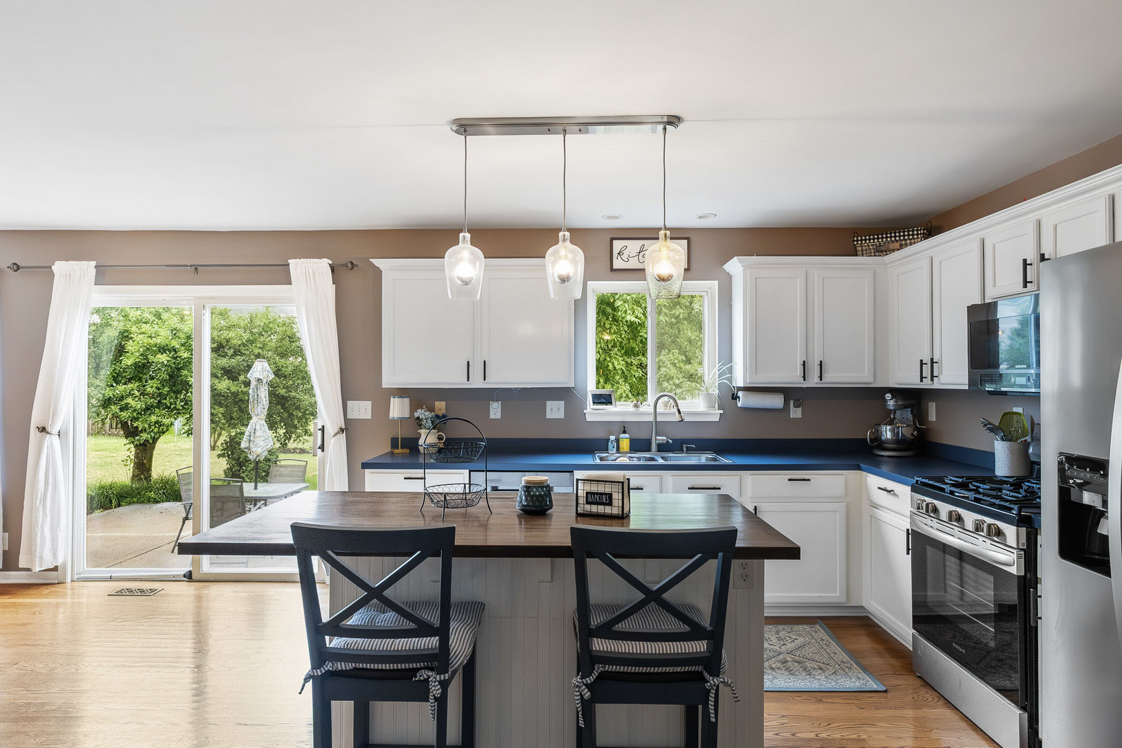 712 Wilson Street Waterman, IL 60556 - Photo 6 of 24 a kitchen with stainless steel appliances a stove a sink a microwave a dining table and chairs