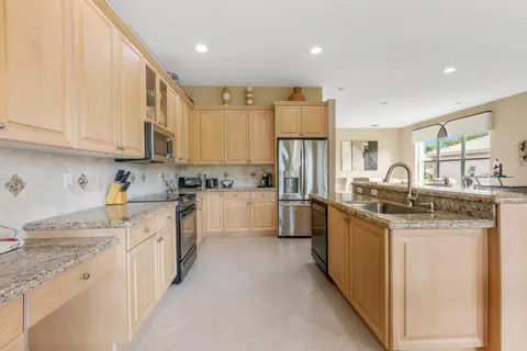 a kitchen with stainless steel appliances granite countertop a stove refrigerator sink and cabinets