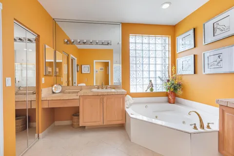 a bathroom with a tub a sink and a large mirror