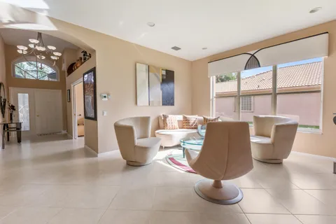 a living room with furniture a chandelier and a large window