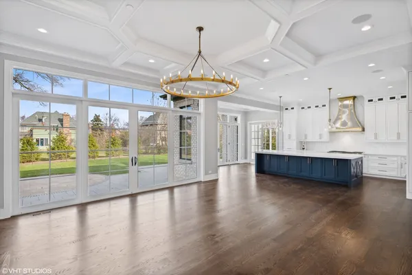 a large kitchen with stainless steel appliances a large center island and a wooden floor