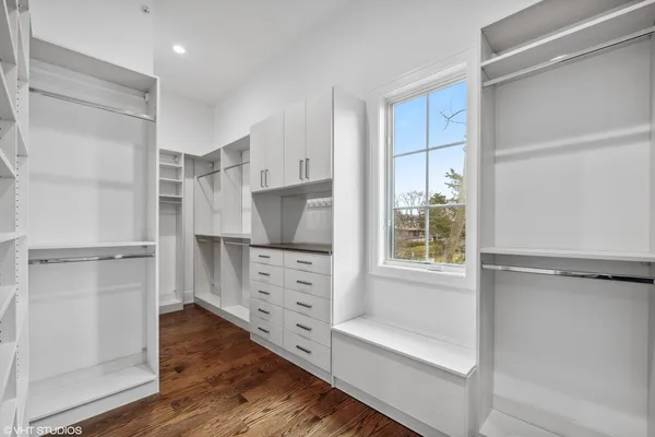 a view of walk in closet with clothes and shoes
