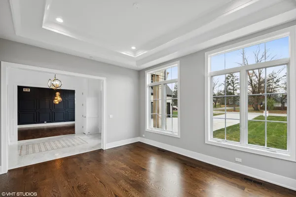 a view of a big room with wooden floor chandeliers and kitchen view