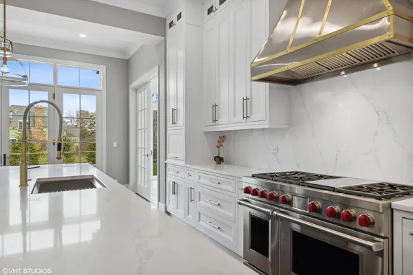a kitchen with stainless steel appliances granite countertop a stove and a white cabinets