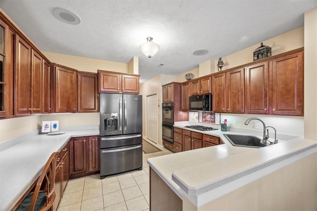 509 Madison Boulevard Freedom, PA 15042 - Photo 9 of 41 a kitchen with stainless steel appliances a sink a stove a refrigerator cabinets and a counter top space