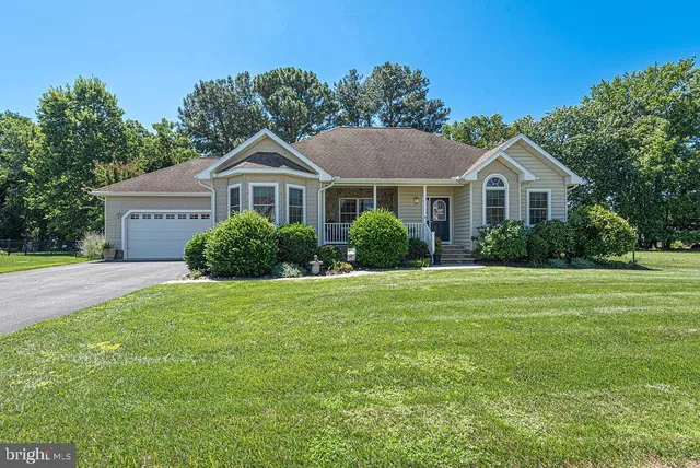 a front view of a house with a yard and trees