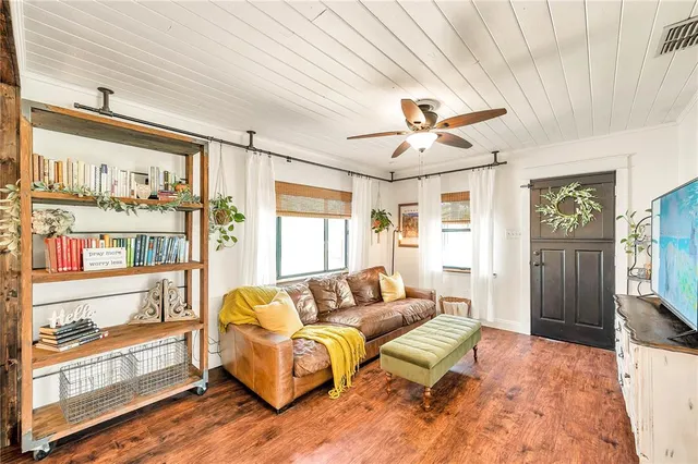a living room with furniture a chandelier and a flat screen tv