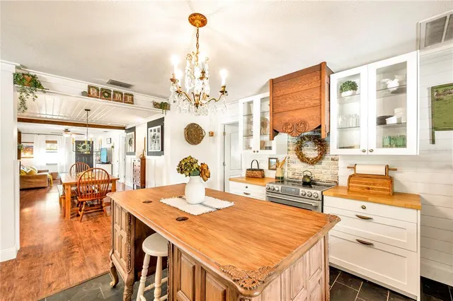 a room with stainless steel appliances kitchen island granite countertop a sink and cabinets