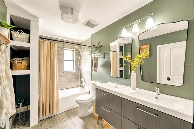 a bathroom with a double vanity sink toilet and shower