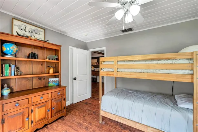 a view of a bedroom with wooden floor and a chandelier