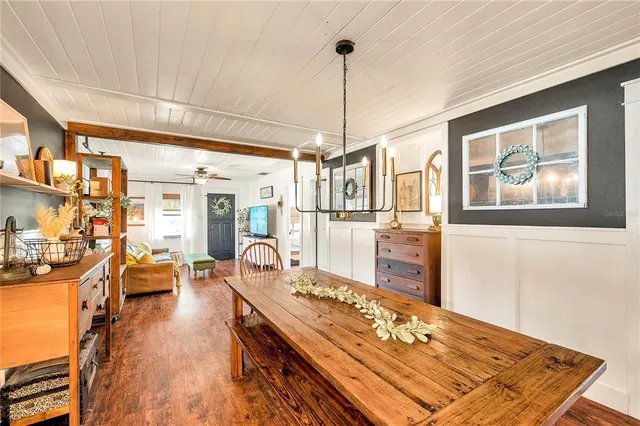a living room with couches a dining table and chairs with wooden floor