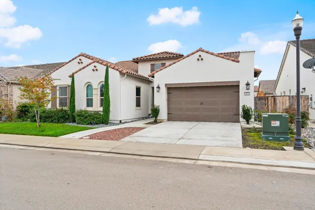 a view of a white house with a yard and plants
