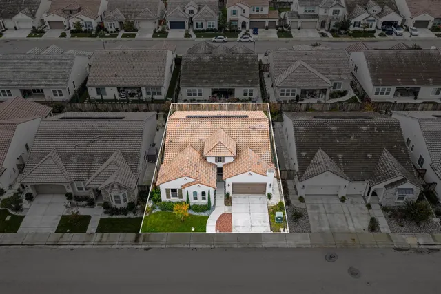 an aerial view of a house with a garden and parking space