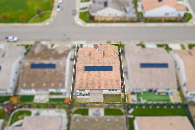 a view of a white house with a yard and plants