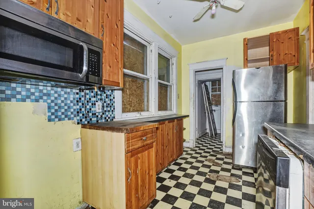 a kitchen with stainless steel appliances granite countertop a refrigerator and a stove top oven