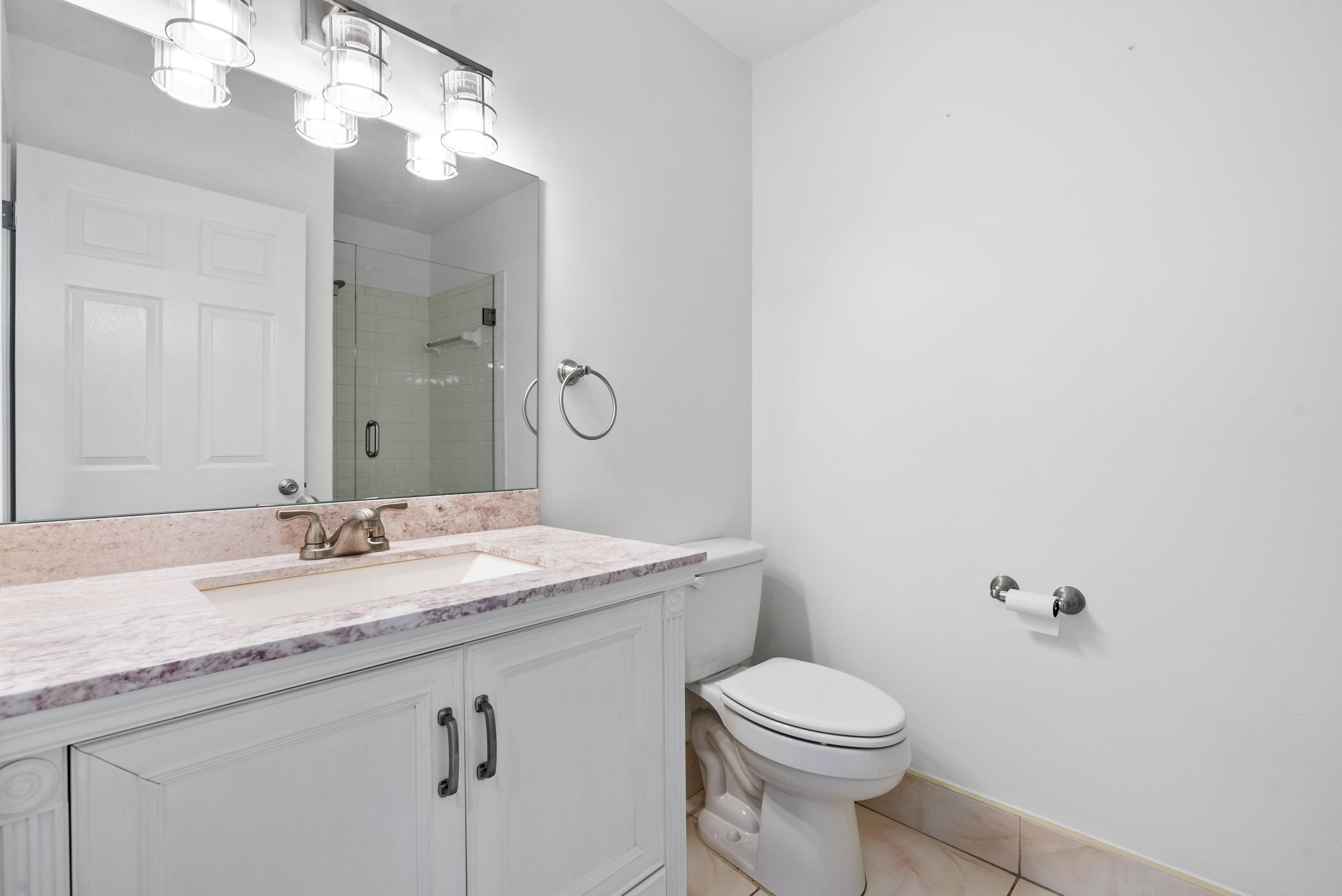 5110 Nesting Way, Unit B Delray Beach, FL 33484 - Photo 13 of 29 a bathroom with a granite countertop toilet sink and mirror