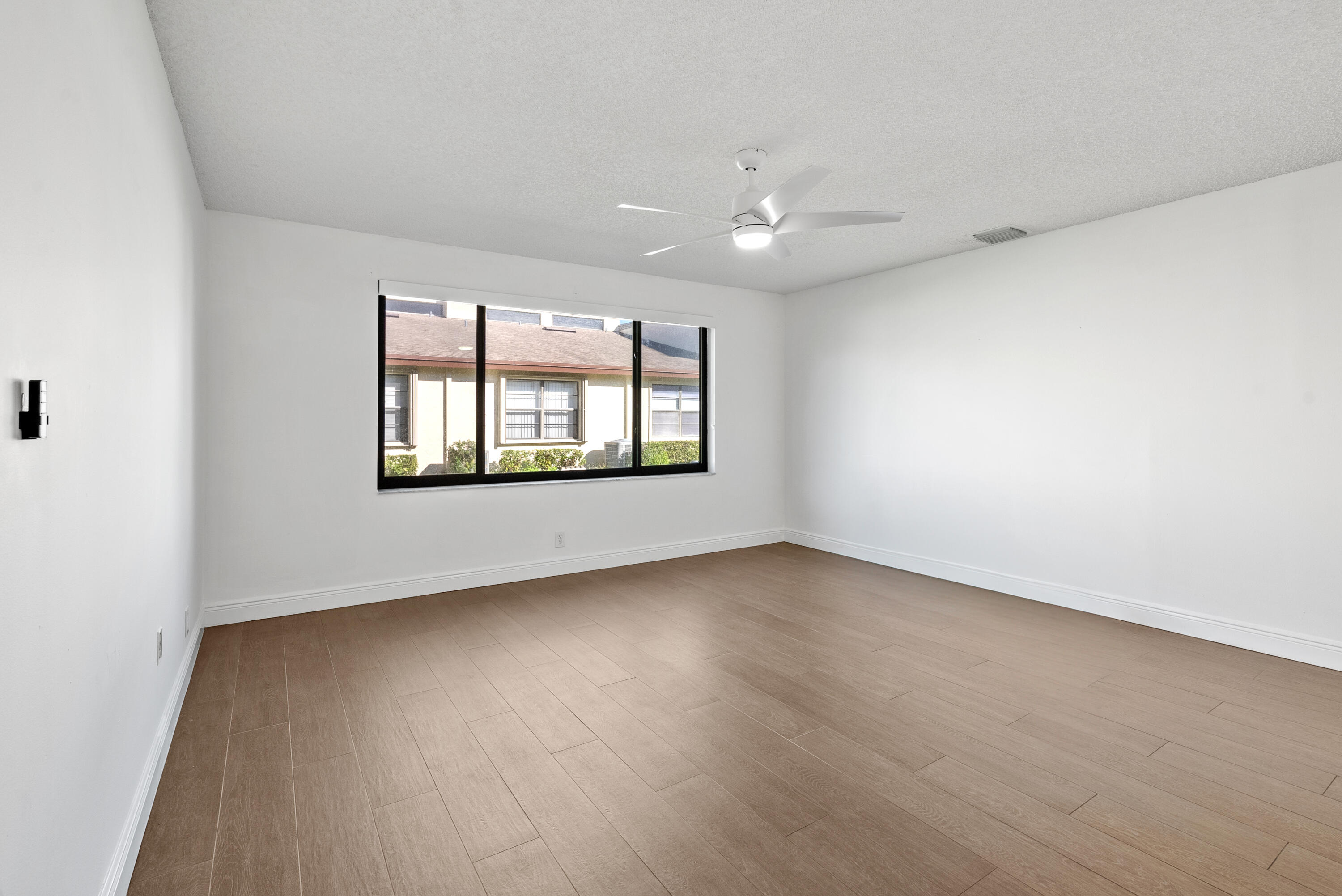 5110 Nesting Way, Unit B Delray Beach, FL 33484 - Photo 14 of 29 an empty room with wooden floor and windows