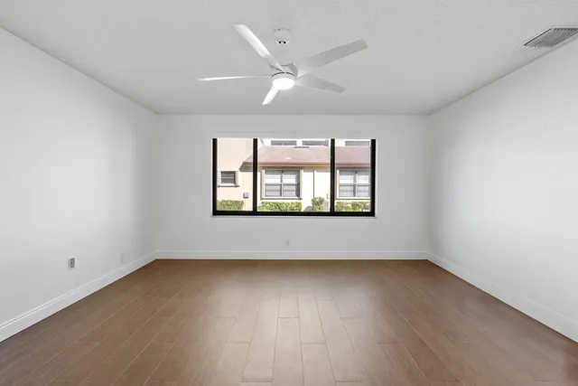 an empty room with a bathroom and a ceiling fan
