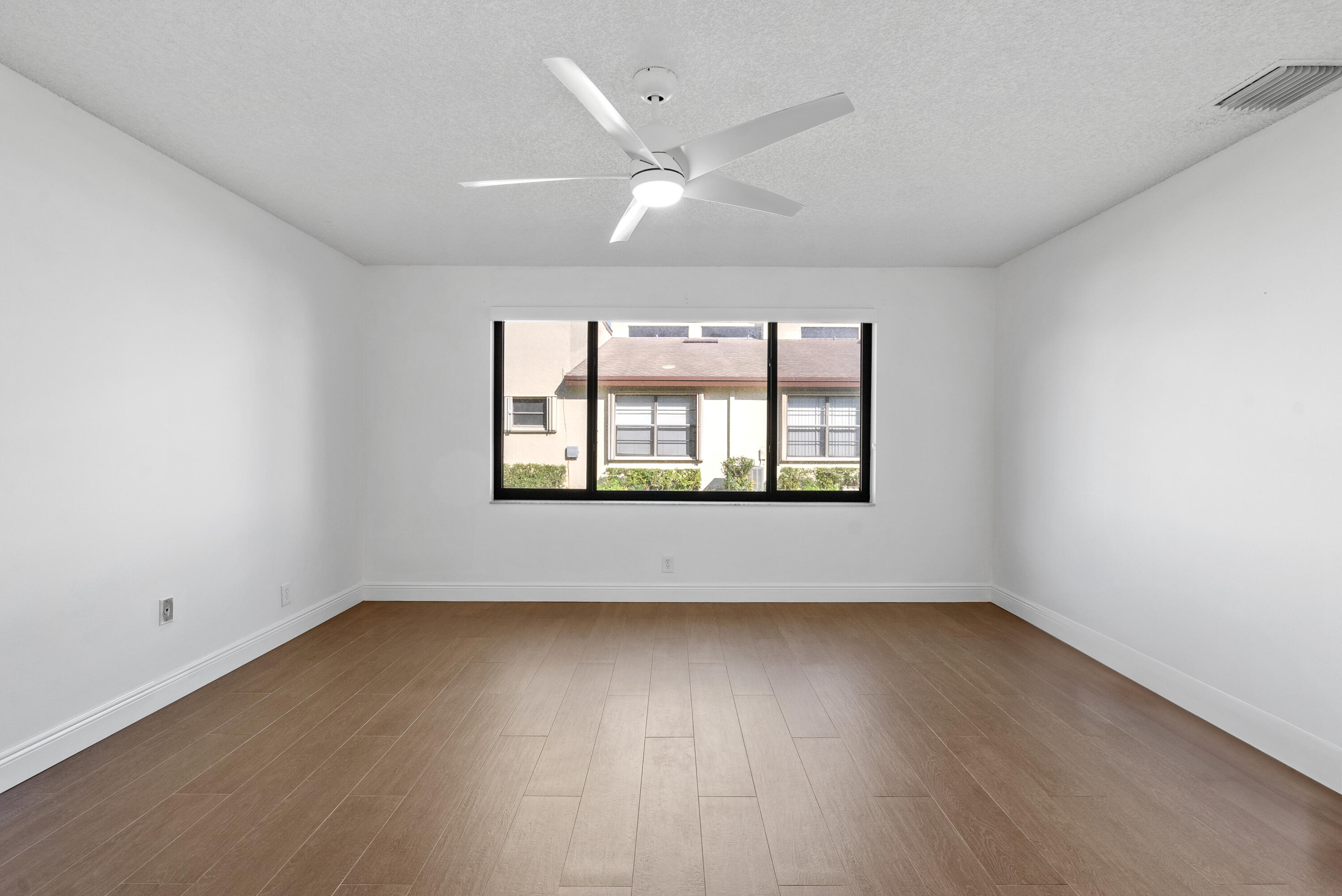 5110 Nesting Way, Unit B Delray Beach, FL 33484 - Photo 15 of 29 an empty room with wooden floor and windows