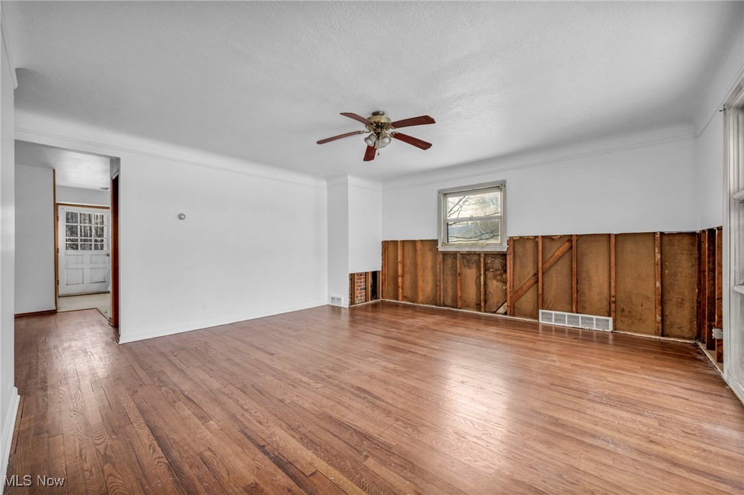 14750 Schreiber Road Maple Heights, OH 44137 - Photo 9 of 44 Unfurnished room with light wood finished floors, ceiling fan, and wood walls