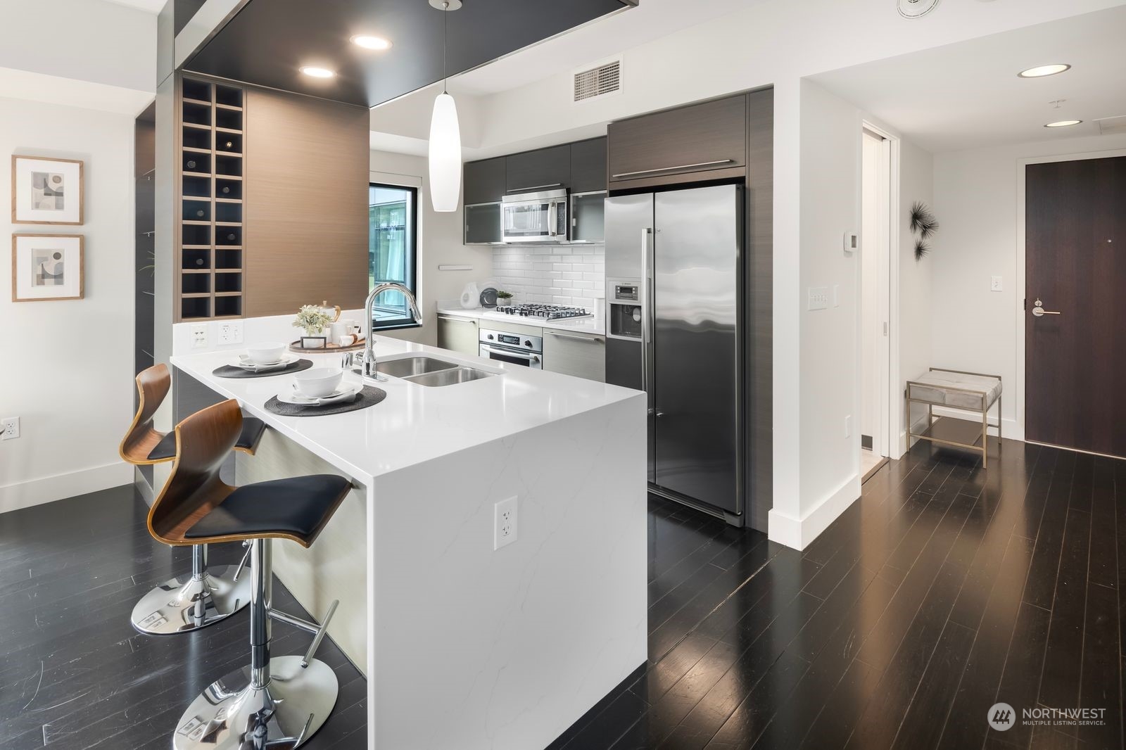 820 Blanchard Street, Unit 708 Seattle, WA 98121 - Photo 10 of 33 a kitchen with stainless steel appliances kitchen island granite countertop a refrigerator a sink a stove and island with wooden floor