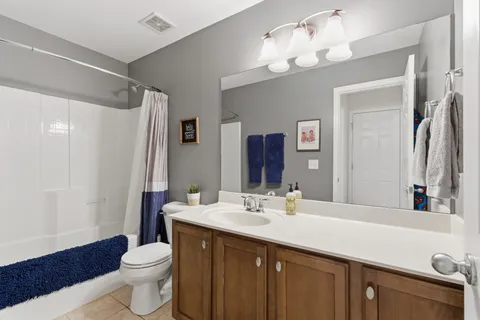 a bathroom with a double vanity sink mirror and toilet