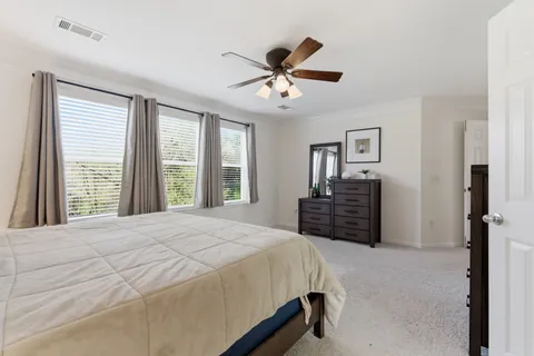 a spacious bedroom with a large bed and a large window