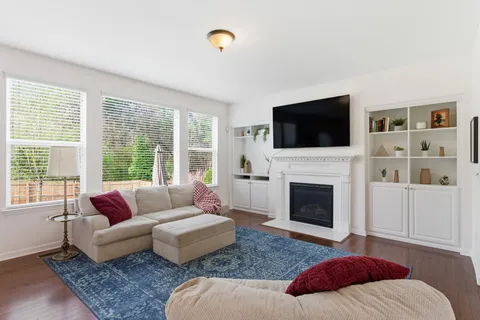 a living room with furniture a fireplace and a flat screen tv