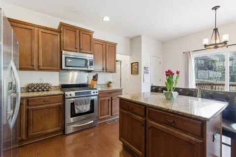a kitchen with kitchen island granite countertop a sink stainless steel appliances and counter space
