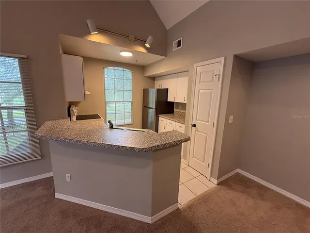 a kitchen with granite countertop a sink and a refrigerator